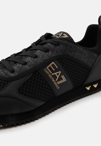 Черни маратонки Emporio Armani EA7 с мрежеста странична панел, златисто лого на страничната част и върха, черни връзки и текстурирана подметка.
