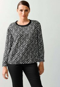 Zwart-wit gestreepte lange mouwen top met een ronde halslijn, met een kettinglinkontwerp en effen zwarte accenten aan de onderkant en bij de mouwen.