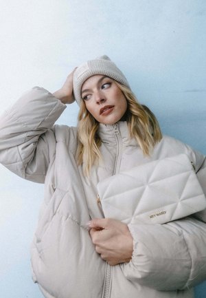 Puffy beige jacket with quilted texture, paired with a light-colored handbag featuring a diamond pattern and gold hardware accents.