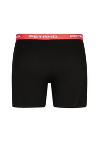Černé boxerky s červeným elastickým pasem se značkou "PETRND." Hladký materiál, přiléhavý střih a délka ke středu stehna.