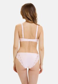 Conjunto de lencería de color rosa claro que incluye un sujetador liso con tirantes finos y una braguita a juego con delicados detalles de encaje en los laterales.