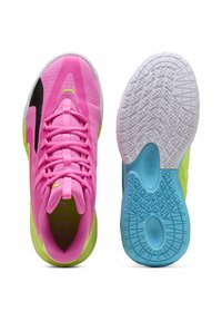 Chaussures de sport rose vif avec tiges en maille, accents noirs et détails vert néon. Les semelles présentent un motif texturé blanc et bleu clair.