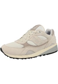 Světlé béžové tenisky vyrobené z textilie a semiše; mají texturovaný svršek, šněrování a gumovou podrážku s černými vzory pro trakci.