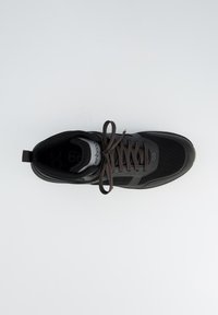 Zwarte sportieve schoen met een bovenwerk van gaas en een rubberen zool. Beschikt over bruine veters, een versterkte hiel en een logodetail op de tong.