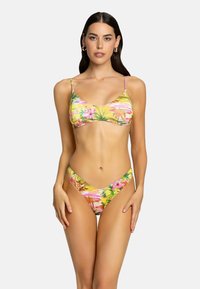 Set bikini floreale con un vivace motivo tropicale. Il top presenta spalline sottili e una forma a triangolo, mentre il lato B ha un design alto.