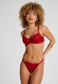 Rotes Spitzen-Dessous-Set mit einem Balconette-BH mit gewellten Rändern und dekorativen Mustern, kombiniert mit einem passenden Low-Rise-String.