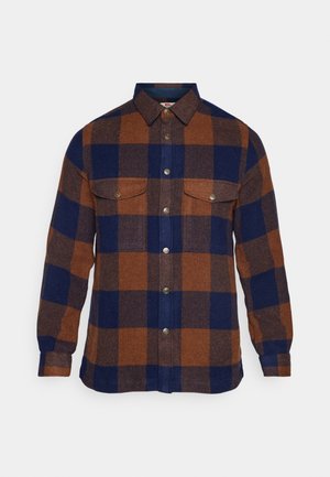 Bruin en marineblauw geruit overhemd van zacht stof, met een knoopsluiting aan de voorkant, twee borstzakken en lange mouwen.