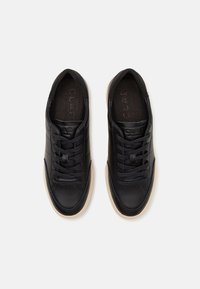 Sorte lær sneakers med en glat overflade, der har en rund tå, snørebåndsdesign og beige gummisål. Prægede logo indeni.