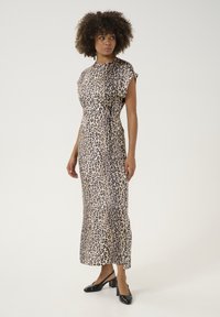Maxiklänning med leopardmönster i beige och bruna nyanser, med korta ärmar och resår i midjan, kombinerad med svarta klackiga slingbacks.