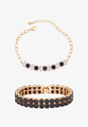 Aranyszínű ékszerszett, amely karkötőt és nyakpántot tartalmaz, fekete kövekkel és áttetsző díszítésekkel, láncszemes kialakítással.