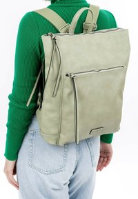 Zaino in pelle verde con spallacci regolabili, chiusura a zip superiore, tasca frontale e distintivi accenti neri sulla zip. Finitura testurizzata.