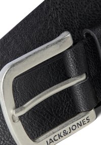Cinturón de cuero negro con hebilla de metal plateado. La textura es de grano fino, con el nombre de la marca "JACK & JONES" grabado en la hebilla.