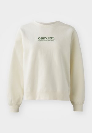 Sweatshirt de crem deschis, fabricat dintr-un material moale. Prezintă un logo verde "OBEY INT." deasupra numelui orașelor. Croire confortabilă cu manșete ribbate.