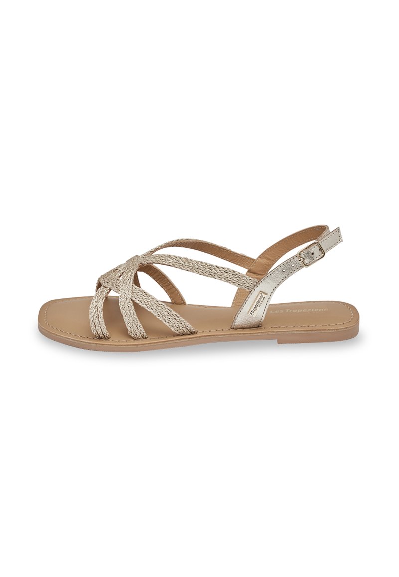 Plat sandalen in lichtbeige met geweven bandjes. Glad leren voetbed en gesp sluiting. Minimalistisch ontwerp met een eenvoudige silhoeet.