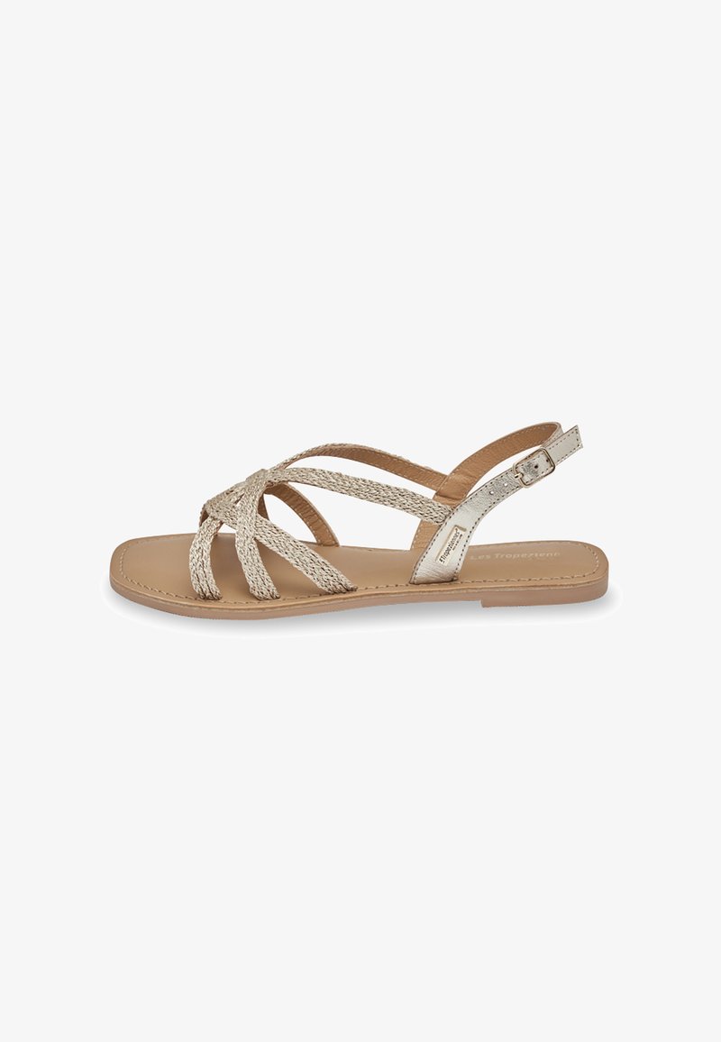 Plat sandalen in lichtbeige met geweven bandjes. Glad leren voetbed en gesp sluiting. Minimalistisch ontwerp met een eenvoudige silhoeet.