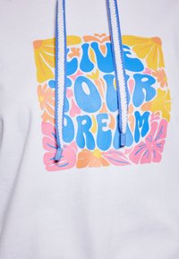 Biely mikina s farebnou grafikou a textom "ŽI SVOJ DREAM" v modrých, ružových, oranžových a žltých kvetinových vzoroch. Modré šnúrky.