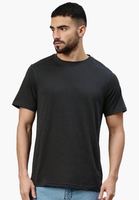 T-shirt nero a maniche corte in un tessuto morbido e leggero, caratterizzato da un classico collo rotondo e una vestibilità rilassata. Dettagli di cucitura sottili.