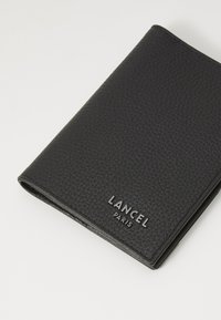 Black leather wallet with a textured surface, featuring embossed "LANCEL PARIS" logo. Closed design, rectangular shape, compact size.