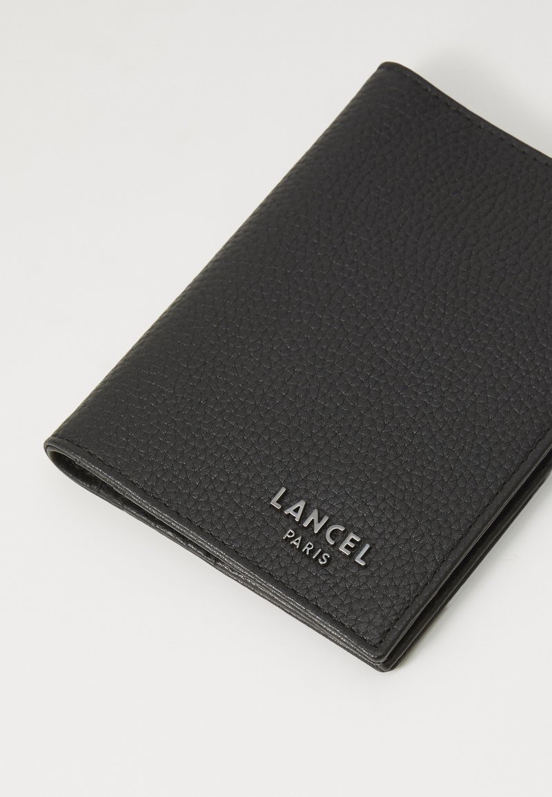 Portefeuille en cuir noir avec une surface texturée, arborant le logo "LANCEL PARIS" en relief. Design fermé, forme rectangulaire, taille compacte.