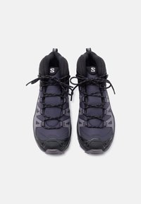 Pereche de bocanci de drumeție negri și gri, cu șireturi negre, guler căptușit și bucle pentru tras, văzuți de sus pe un fundal alb.