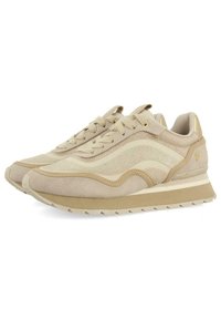 Des chaussures de course beiges présentent un mélange de cuir suédé et de maille, des accents texturés, des rayures tonales, des lacets plats et une semelle rembourrée.