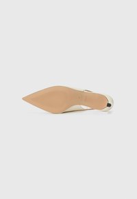 Chaussure à talon aiguille à bout pointu avec une tige synthétique beige, une semelle en cuir et un talon fin. Pas de matériel ni de motifs visibles. Texture lisse.