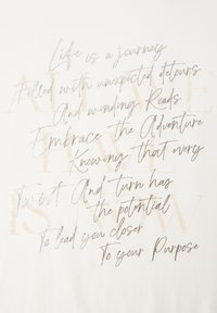 Bílý textilní pozadí obsahuje kombinaci kurzívního a blokového písma ve stříbrné a béžové barvě, zobrazující motivační fráze o životní cestě.