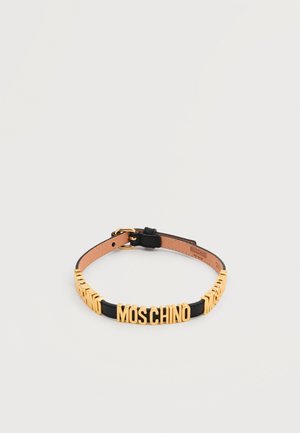 Svart lærhalsbånd med justerbar spenne og gullbokstaver som staver "MOSCHINO" foran.