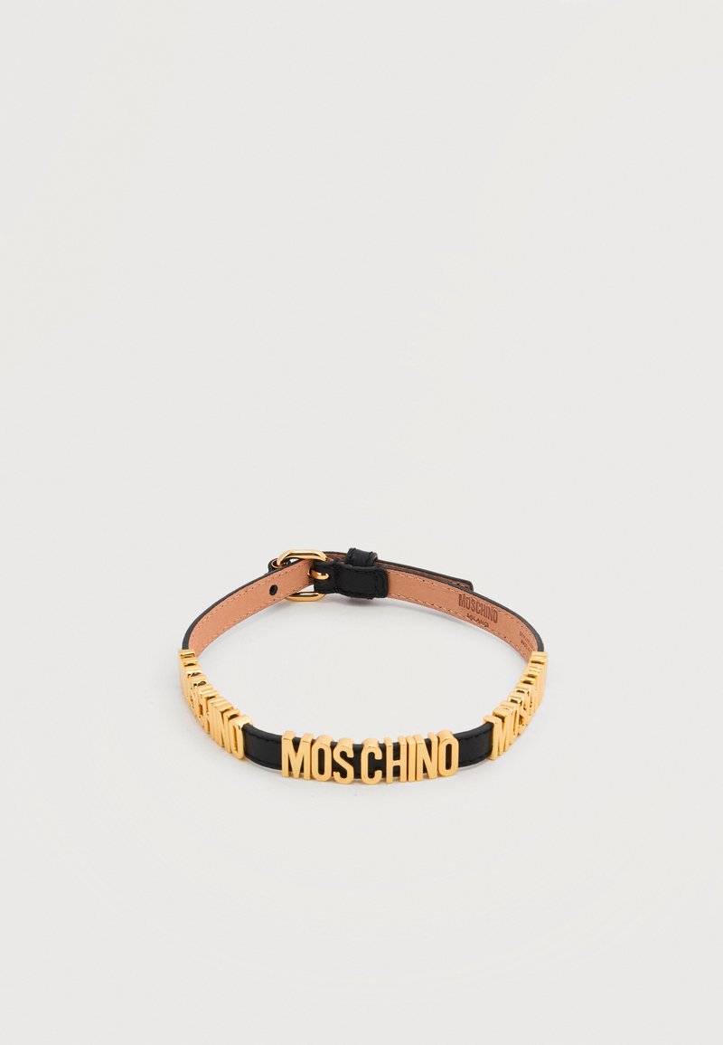 Μαύρο δερμάτινο περιλαίμιο με ρυθμιζόμενο πόμολο και χρυσά γράμματα που σχηματίζουν τη λέξη "MOSCHINO" κατά μήκος του μπροστινού μέρους.