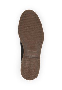 Semelle en cuir noir avec une finition texturée semblable au caoutchouc. Motif marron en relief notable pour une meilleure adhérence ; logo "Marc O'Polo" visible.