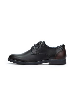 Chaussure de ville noire en cuir avec un bout arrondi, un laçage, un accent marron au talon et une semelle texturée pour une bonne adhérence.
