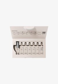 Set de soins de la peau dans une boîte beige contenant sept ampoules en verre transparent étiquetées "LIFT" et un applicateur en argent. Comprend des instructions d'utilisation sur le couvercle.