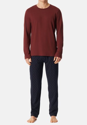 Rotes Langarmshirt, kombiniert mit navyblauen, gemusterten Schlafanzughosen mit kleinen roten Akzenten, aus Baumwolle und in lockerer Passform.