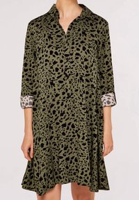 Grøn kjole med sort dyreprint, med krave og trekvartærmer. Manchetterne har et kontrasterende lyst gråt mønster.