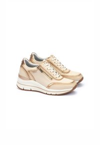 Baskets beiges avec une finition en cuir lisse, dotées d'une fermeture éclair sur le côté, de lacets blancs, et d'une semelle blanche rembourrée avec des accents texturés.