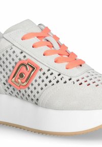 Tenis gri din suede cu un design perforat, șireturi portocalii și un logo roz. Dispune de o talpă albă, de tip platformă, cu margini texturate.