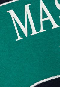 Telas verdes con el texto blanco que dice "MAST." Presenta una apariencia texturizada con un borde negro.