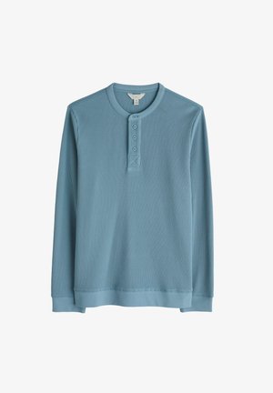 Hele sinine pika varrukaga henley särk, millel on tekstureeritud ribadesign, ümmargune kaelus, kolme nupuga pilu ja elastsed mansetid.