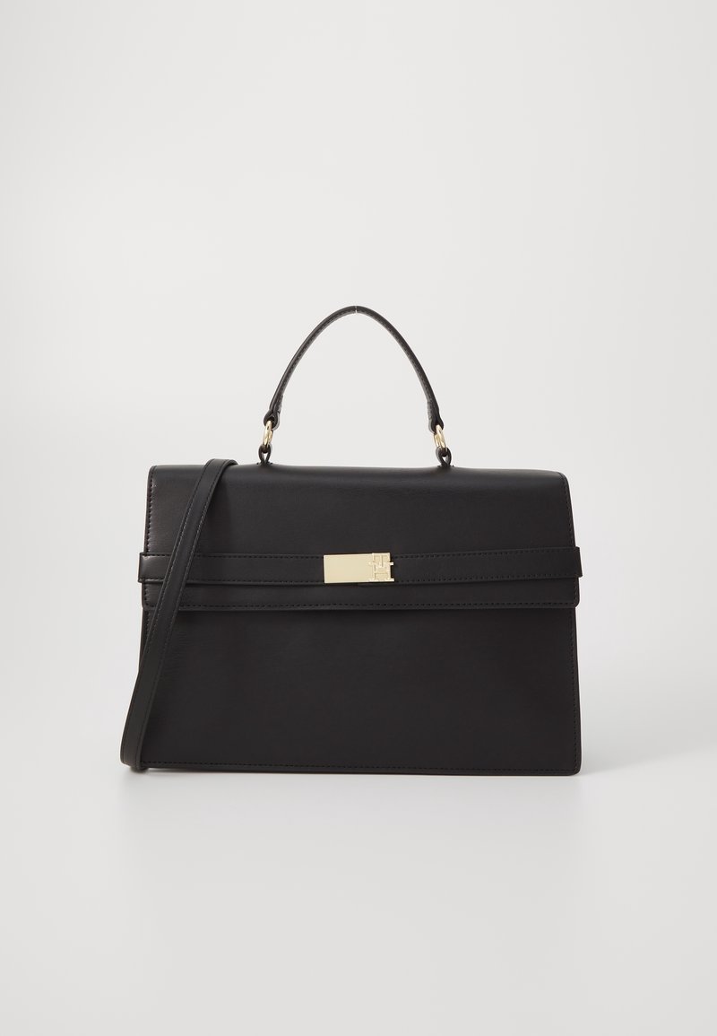 Sac à main rectangulaire en cuir noir avec poignée supérieure, fermoir doré et bandoulière amovible sur un fond blanc uni.