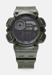 Montre numérique Casio avec un boîtier et un bracelet en plastique vert olive mat. Équipée d'un cadran analogique-numérique avec de multiples fonctions et une résistance à l'eau.