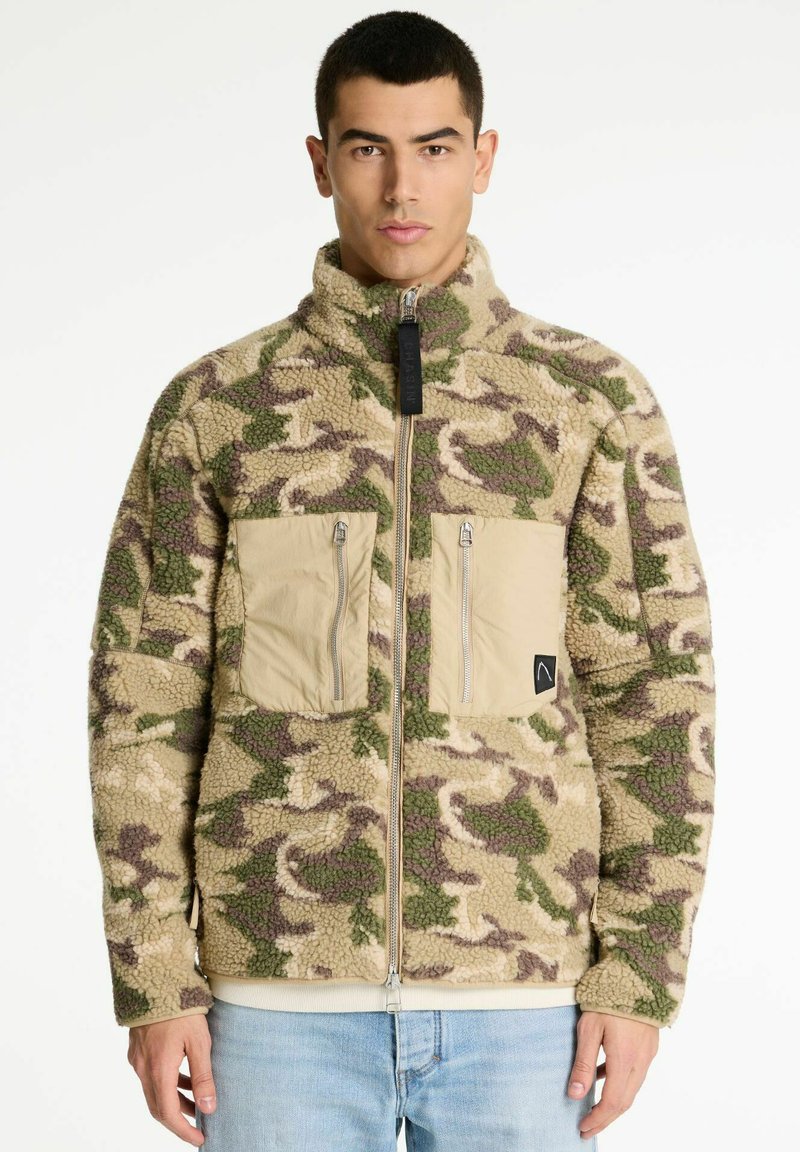 Fleecejack in een camo-patroon met tinten groen en bruin. Beschikt over een hoge kraag, een front-rits en twee beige ritszakken.