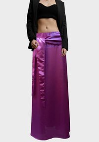 Falda maxi de satén púrpura con un lazo en la cintura, que presenta un efecto degradado. La textura transparente crea un diseño fluido.