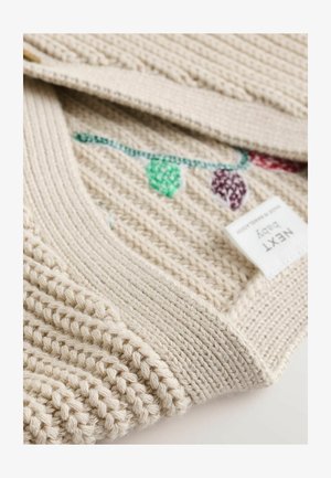 Cardigan per neonati in maglia beige con colletto a costine, decorato con forme ricamate colorate e un'etichetta con il marchio "NEXT baby".
