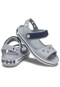 Grå plastsandaler med en marineblå rem og cirkulære udskæringer. Hvid sål med marineblå stripe og "Crocs" branding. Tekstureret indersål.