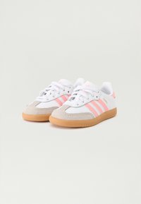 White athletic shoes with pink stripes, suede toe cap, and a gum rubber sole. Features lace-up design and padded collar for comfort.