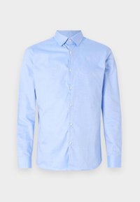 Světle modrá, dlouhá košile s knoflíky má límec, přední zapínání na knoflíky a texturovaný detail na vnitřní straně límce. Hladký povrch látky.