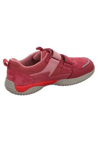 Roter und rosa Sportschuh aus einer Mischung von Wildleder und Mesh-Materialien, mit Klettverschlüssen und einer strukturierten Gummisohle mit einem kontrastierenden Akzent.