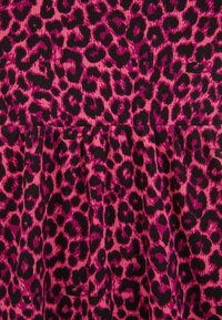 Tkanina s leopardjim vzorom v odtenkih roza in črne, z rebrasto teksturo. Vzorec vključuje različne velikosti leopardjih madežev.