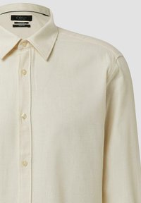 Camicia a maniche lunghe color crema con chiusura frontale con bottoni, colletto classico e marchio S. Oliver Black Label sull'etichetta interna del colletto.