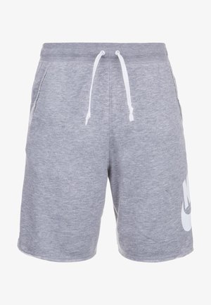 Pantalones cortos Nike de color gris claro con cordón blanco y bolsillos laterales, con un gran logotipo blanco de Nike en la parte inferior de la pierna izquierda.